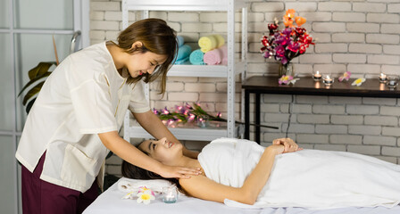 Asian young oriental professional female masseuse therapist stand massaging shoulder and back of...