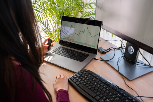 Woman Holding Cold Wallet In Front Of Crypto Graph