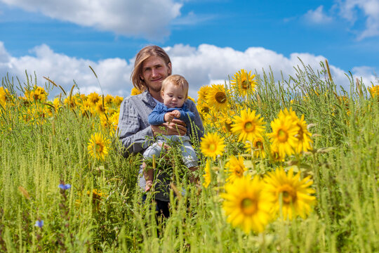 Father and son in sunflower field 