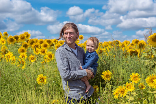 Father and son in sunflower field 