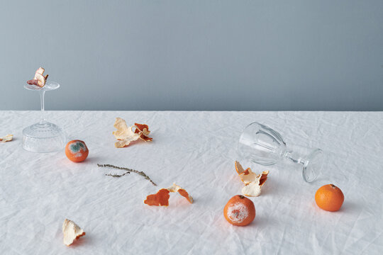 Rotten Tangerines And Glassware On Table