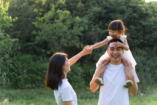 Happy family with kid walking on the meadow