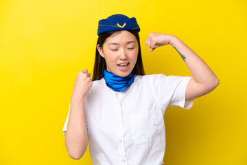 Airplane Chinese woman stewardess isolated on yellow background celebrating a victory