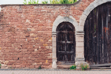 Fototapeta na wymiar old stone wall with wooden gate in germany