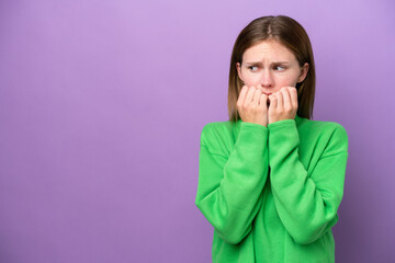 Young English woman isolated on purple background nervous and scared putting hands to mouth