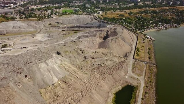 Aerial of metallurgical plants slag, scrap dump heap from metallurgical furnaces near sea of Azov. Slag heap from industrial production waste. Harmful production and air pollution. Ecological issues.