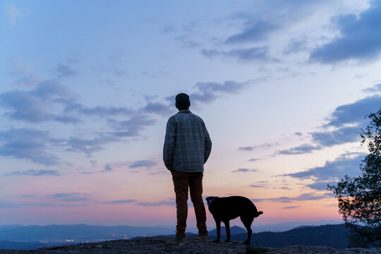 silhouette  Portrait of man and dog  exploring nature at sunset