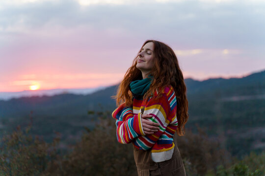 Portrait of happy relaxed woman in nature at sunset 