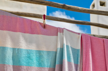 Swimming Towels Drying. Copy Space.  Selective Focus .Decorative towels hanging on a clothesline. Sky and chimney in the background. Stock Image.