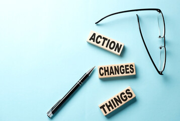 Action Changes Things text on wooden block ,blue background