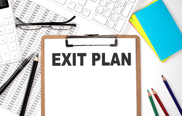 Clipboard with text EXIT PLAN keyboard and chart on white background.