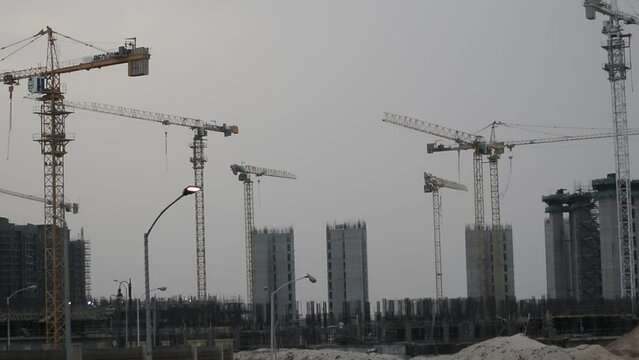 Construction site of new buildings in Egypt, acres of luxurious real estate residential buildings under construction with cranes, selective focus