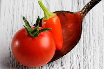 Small red ripe tomato with red hot pepper