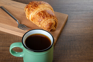 Croissant with a cup of full coffee ,directly above