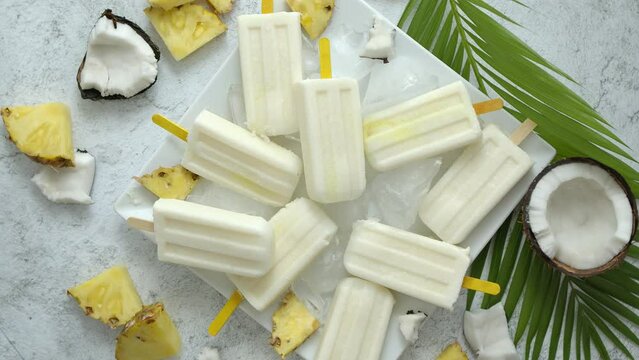 Summer popsicles on stick. Pinacolada flavour. Made with pineapple, cocount milk, rum. Vegan snack