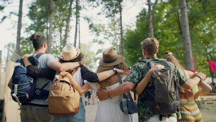 Rear view of group of young friends at summer festival, walking.