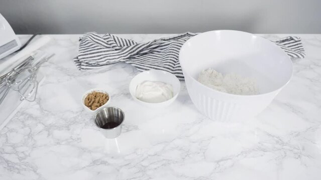 Time lapse. Step by step. Ingredients to bake cranberry muffins on a marble kitchen surface.