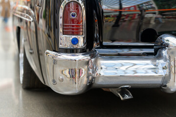 Black and glossy retro car, close-up. View of the rear lights