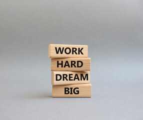 Work and dream symbol. Wooden blocks with words 'Work Hard Dream Big'. Beautiful grey background....