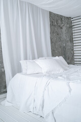 Large four-poster bed with white linen
