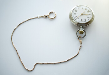 Pocket mechanical watch of the last century on a white background.Silver watch with gold chain. Pawnshop. Buying antiques.Search for old things.The passing time.