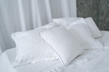 Fototapeta na wymiar White pillows on a white bed