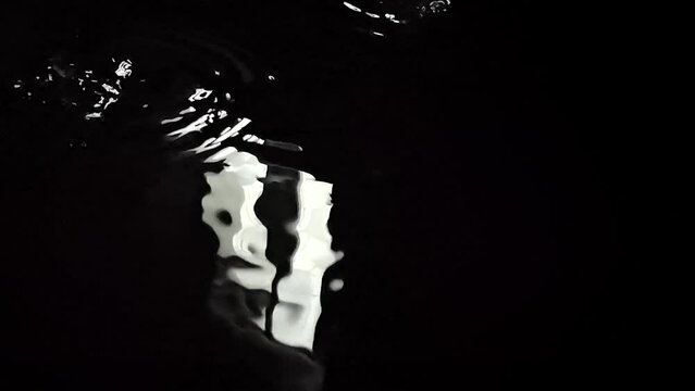 Morning sun rays from window in black water reflection wit rain drops in super slow motion cinematic video. Filmed on high speed cinematic camera at 1000 fps. High quality FullHD footage