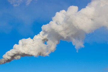 Thick white smoke against bright blue sky background. Concept ecology. Air pollution. Global...
