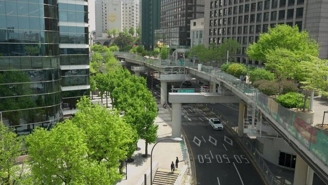 Korean police car with flashing beacons driving under Seoullo 7017 skygarden park - elevated view