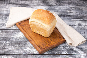 Bread, on a white wooden background, wooden plate