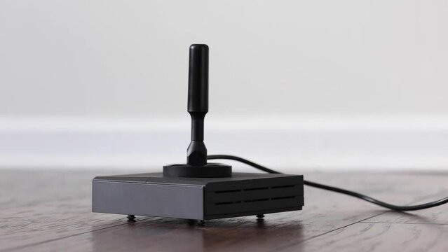Aerial antenna on top of electronic device for mining helium cryptocurrency placed on hardwood floor of domestic room