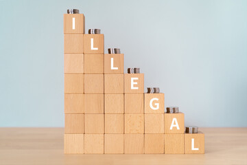 不法・違法のイメージ｜「ILLEGAL」と書かれた積み木とコイン