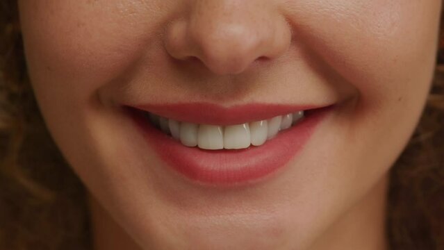 Close up of a charming woman smile with perfect natural teeth and bright lipstick
