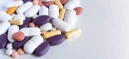 Pharmacy background on a white table. Close up of different kind of pills and capsules.