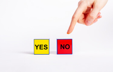 Choice between positive and negative decisions concept. Forefinger pointing to red cube with no...