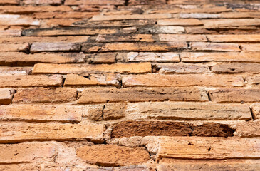 Blurred background of an old brown brick wall in an ancient Thai temple.