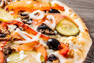 vegetarian pizza with Mozzarella cheese, grilled zucchini, mushrooms, red onion, pepper and olive. Italian pizza on wooden table background