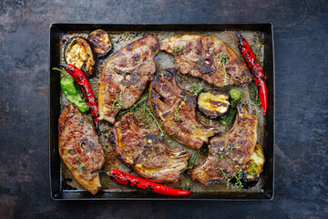Gegrillte Lammrückensteaks mit Chili und Kräuter serviert als Draufsicht auf einem rustikalen Metall Tablett