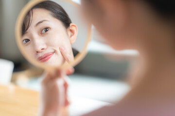 鏡を見て悩む女性