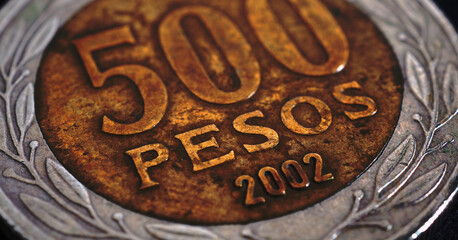 Translation: 500 pesos. Coin of 500 Chilean pesos close-up. Peso of Chile. News about economy or banking. Loan and credit. Money and taxes. Horizontal stories. Macro