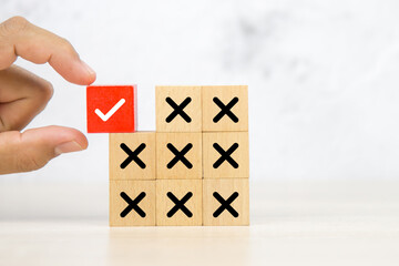 Hand choose wooden block stack with check mark and cross symbol for customer survey service and feedback.