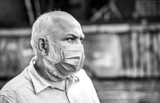 Coronavirus, illness, infection, quarantine, medical mask. Old man wearing face mask. Portrait of an old man, years old, in a medical mask. Concept danger of coronavirus for the elderly.