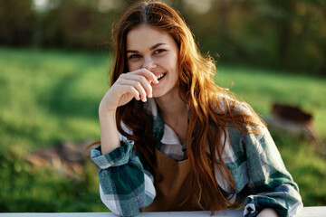 A woman laughing and smiling in nature in a green park