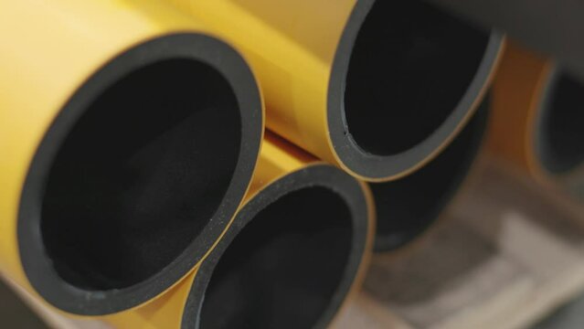 Close up shot of PE pressure gas pipe. Large yellow plastic pipe. Construction and infrastructure themes. Colorful plastic product and usage.