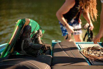 selective focus on black boot of wakeboard on motorboat board