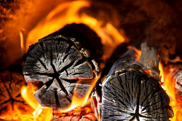 Burning firewood in fire-box of boiler in country cottage.