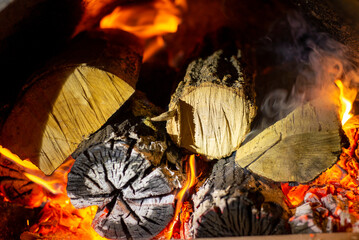 Burning firewood in fire-box of boiler in country cottage.