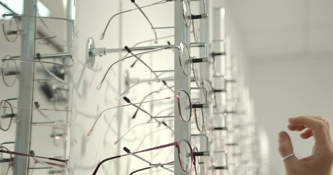 Close-up view of an optician removes glasses from a shop window.