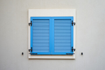 Blue plastic window shutters on a wall of residential building