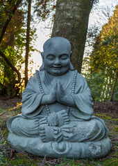 Statue of peaceful Buddha meditating under a tree. Meditation. Mental health awareness.